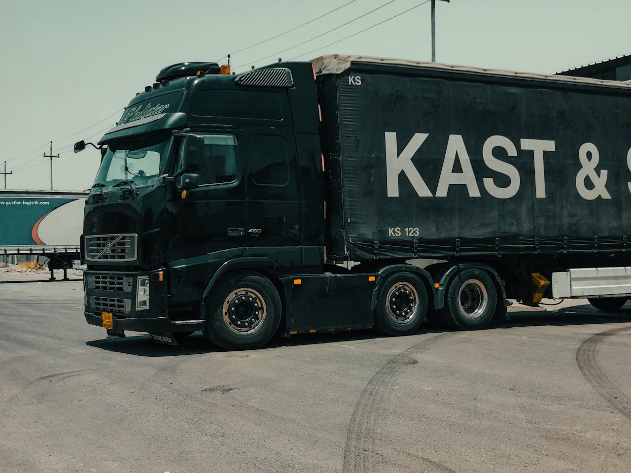 services-04 A large industrial truck parked in an urban setting, showcasing transportation industry visuals.