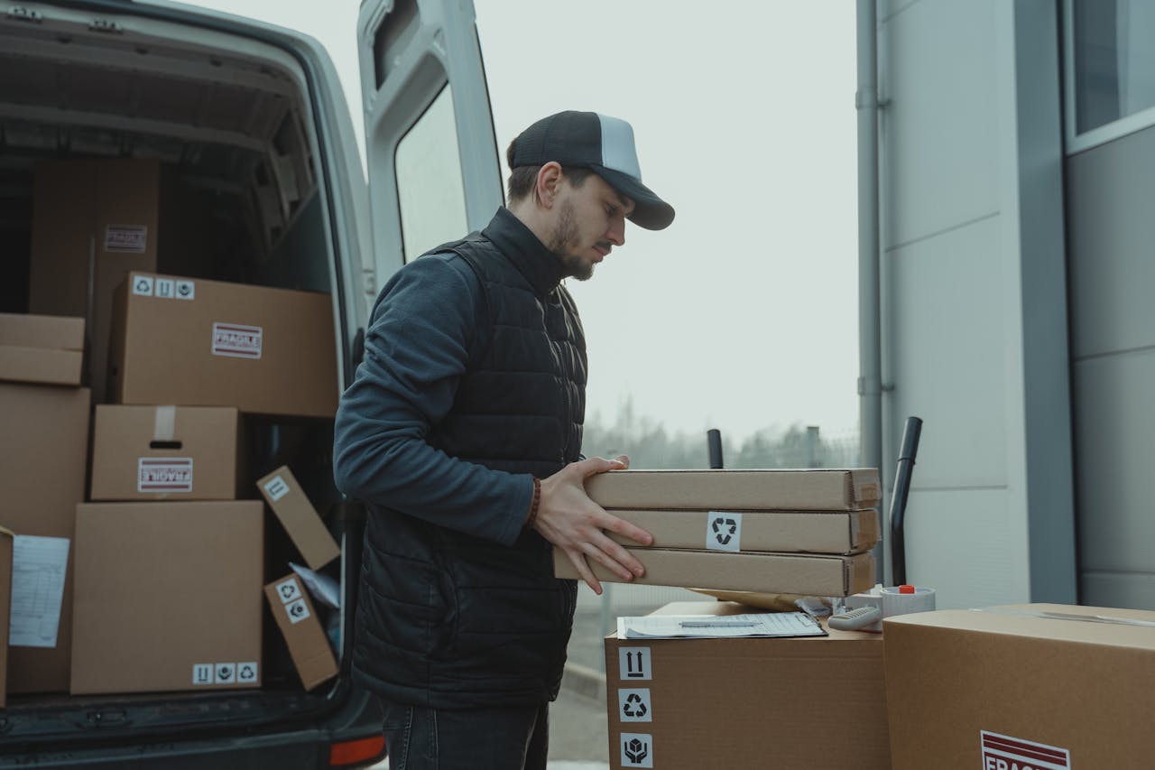 services-02 Delivery driver handling cardboard boxes during shipping at a commercial building.